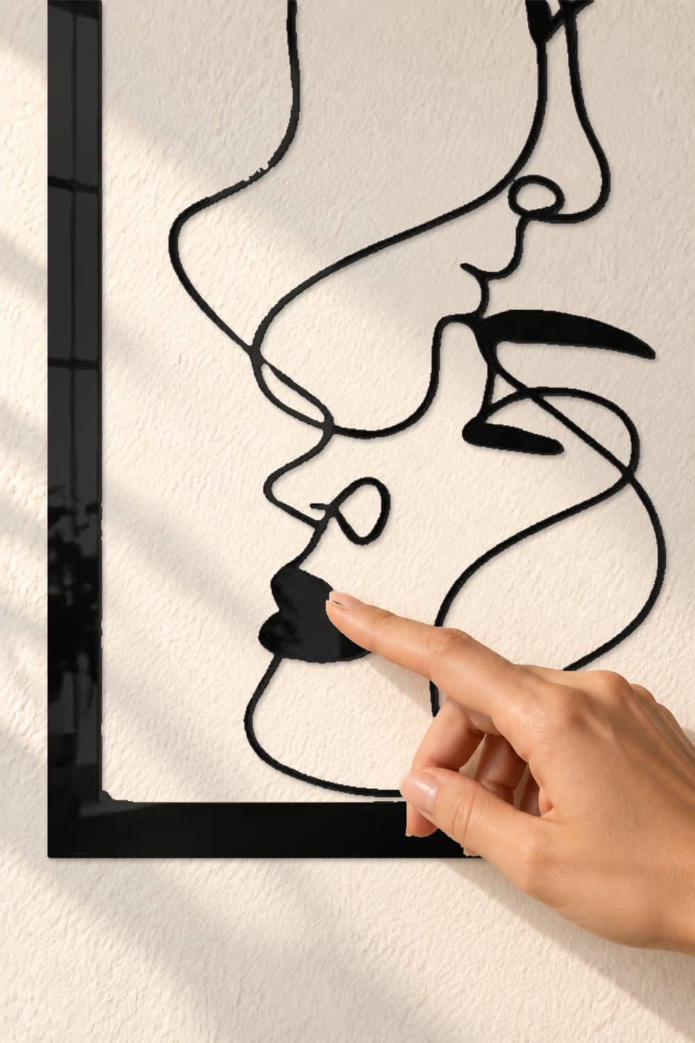 Caras, detalle del aluminio negro brillante con un dedo tocando suavemente el diseño