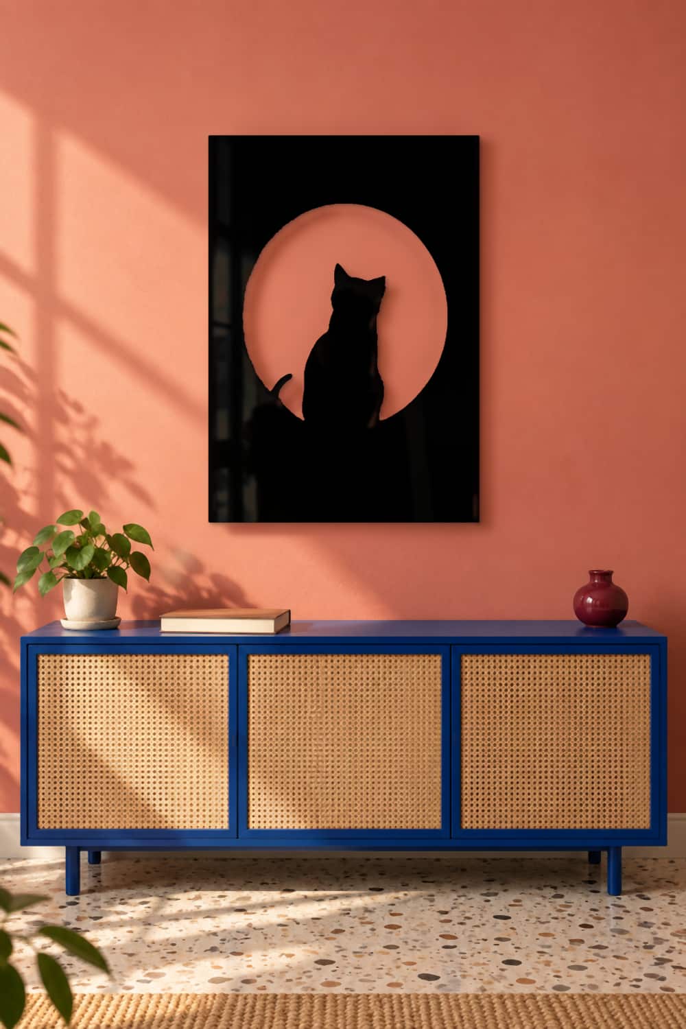 Cat On The Moon en salón coral con aparador azul y ratán.