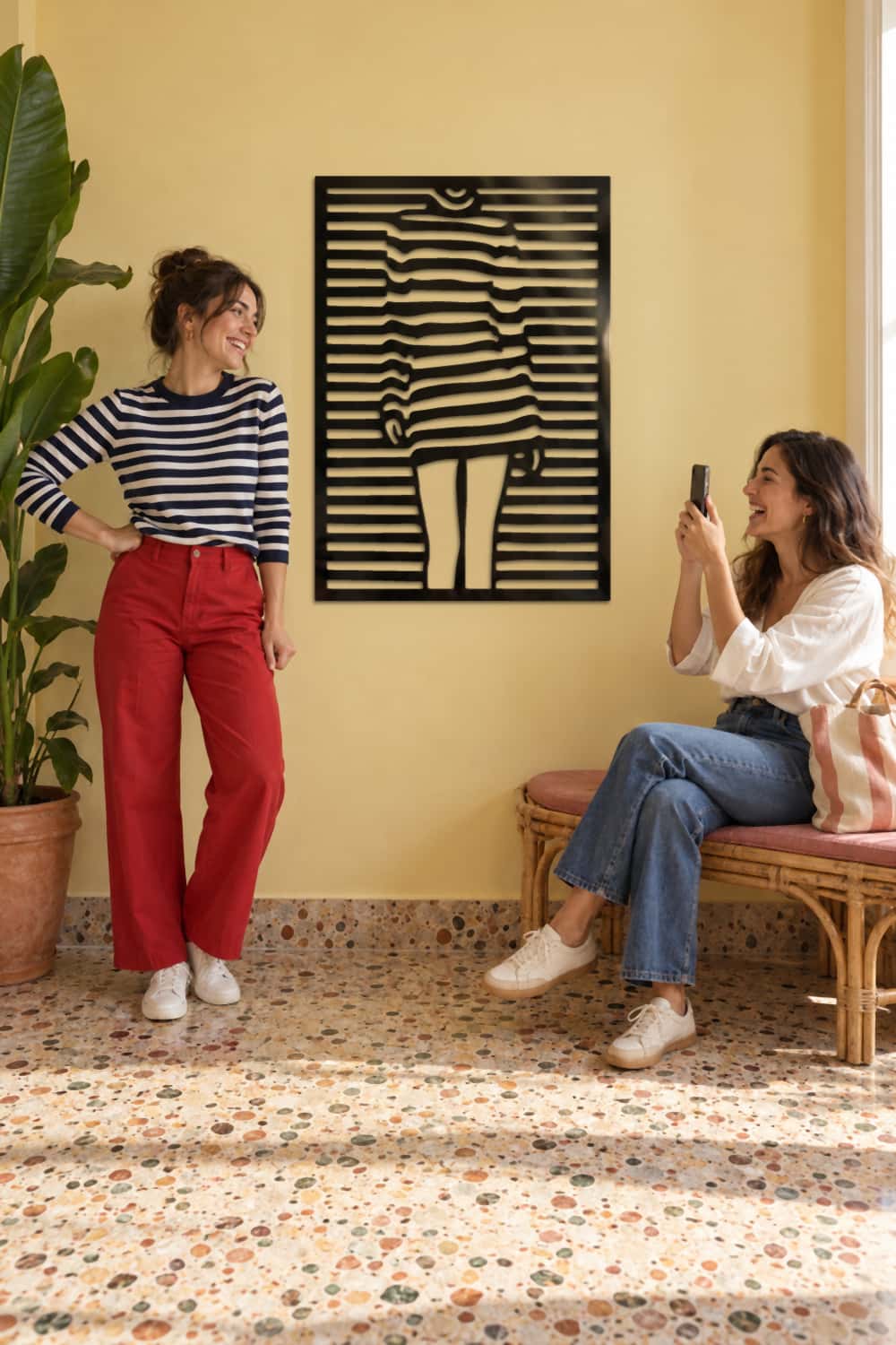 Cuadro Chica Pop en recibidor amarillo: una chica imita su pose y su amiga le hace una foto