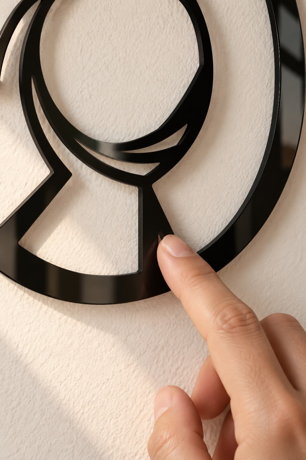 Circle: detalle del aluminio negro brillante con un dedo tocando la unión de los círculos