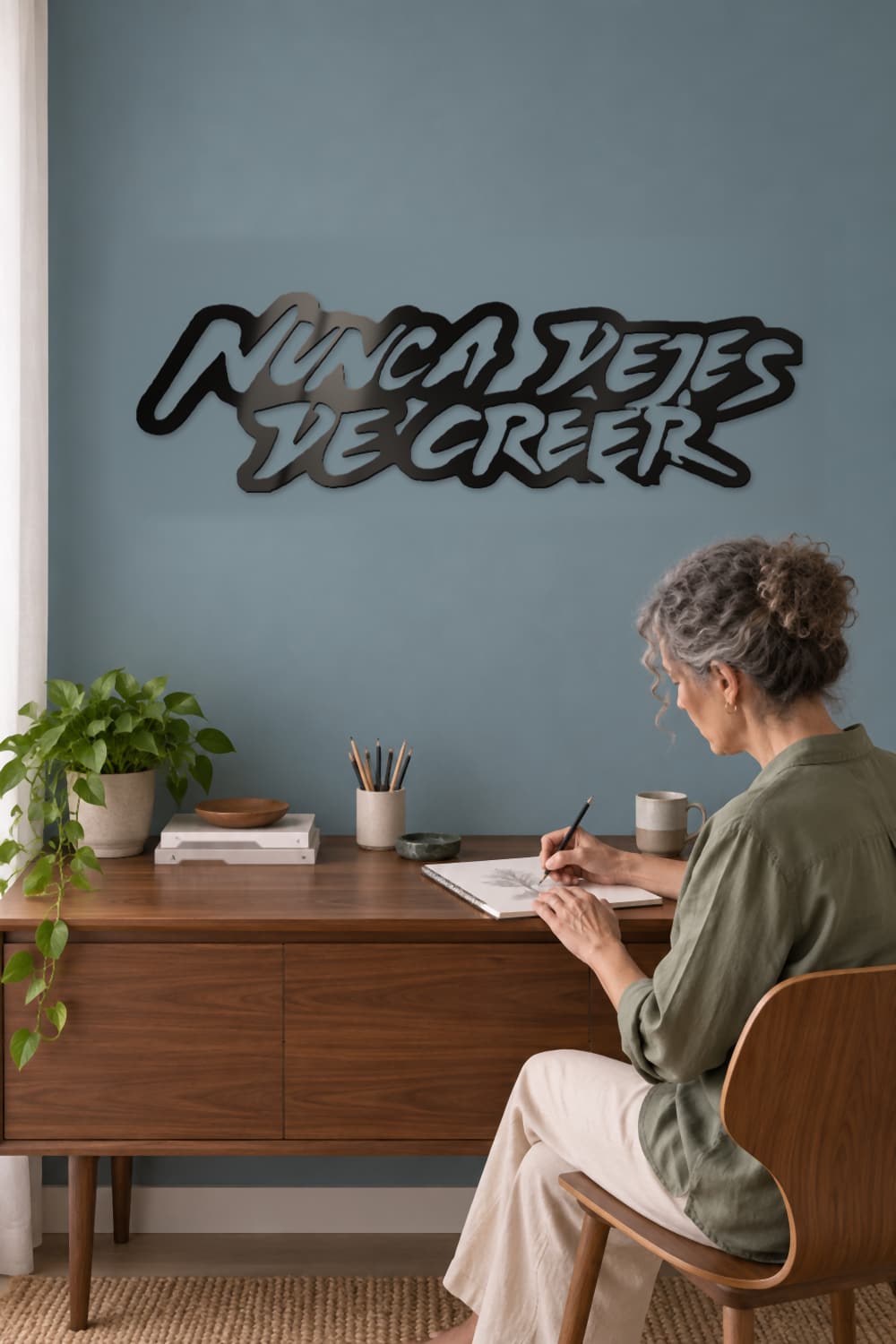 Nunca Dejes De Creer en estudio azul con una mujer practicando dibujo