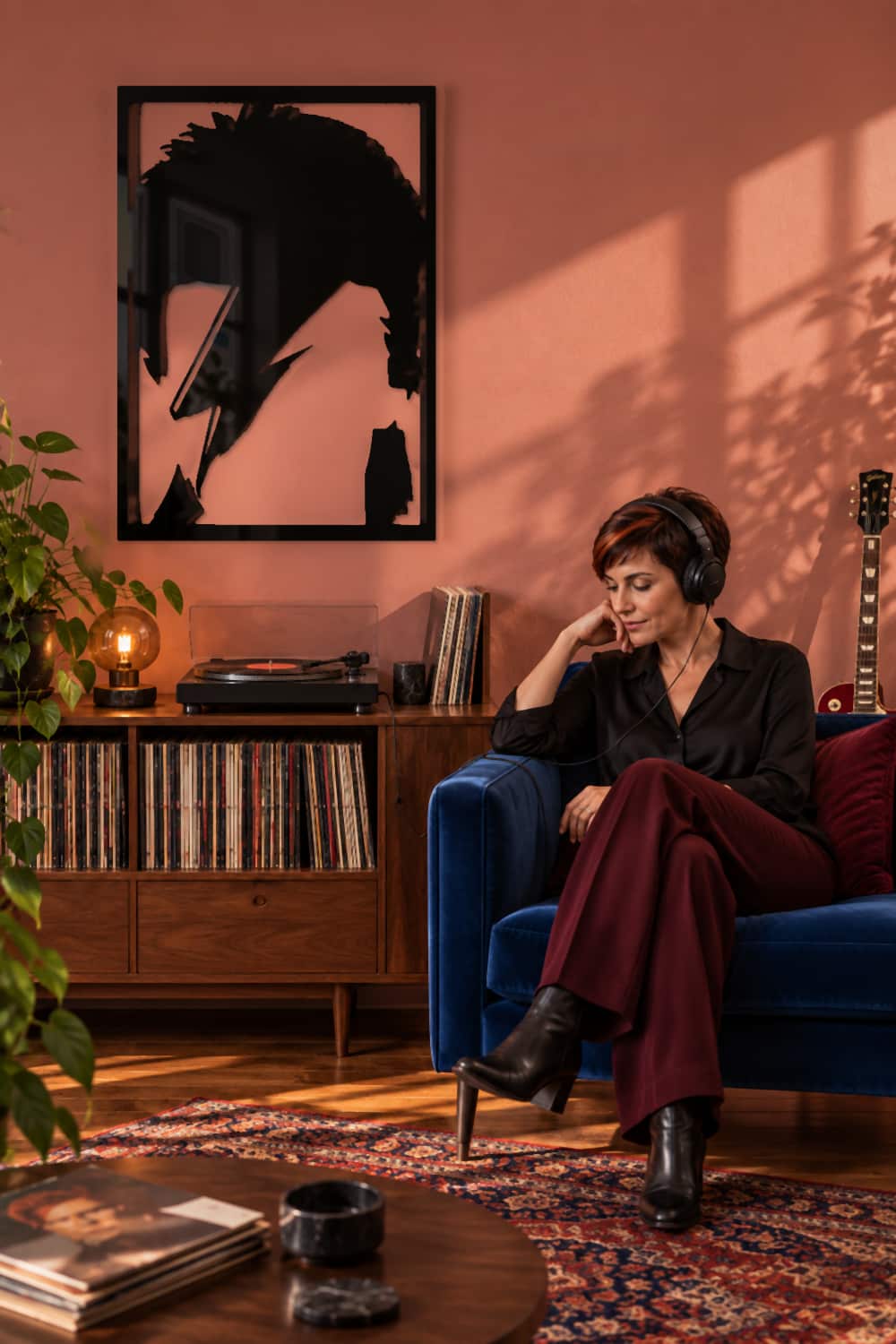 David Bowie junto a una melómana que escucha vinilos con auriculares en un salón de color