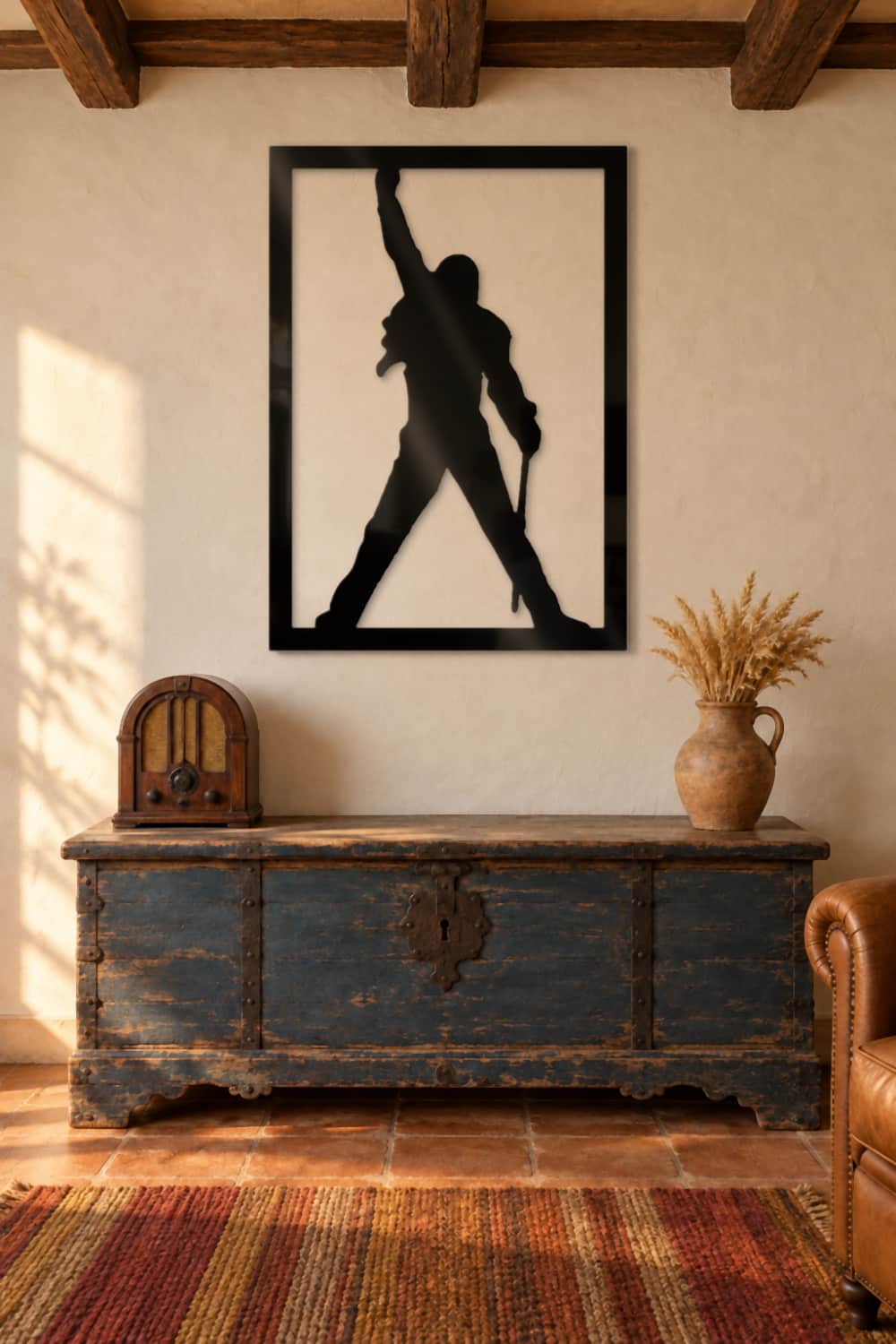 Cuadro Freddie Mercury en aluminio negro brillante sobre un arcón antiguo en un salón rústico con vigas