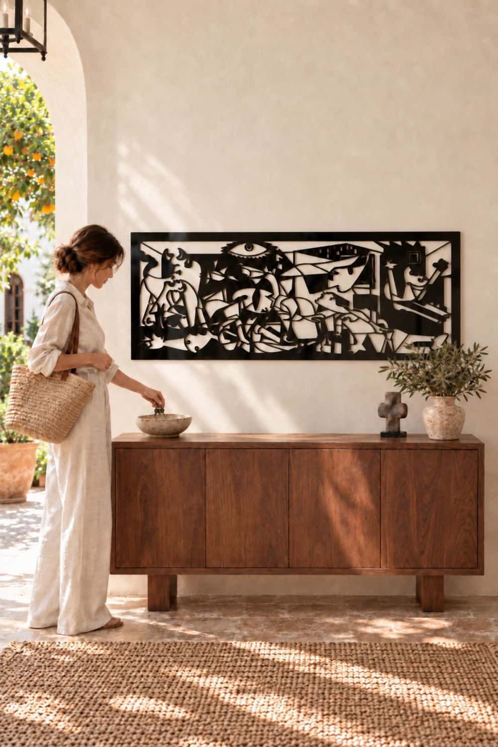 Recibidor con el cuadro del Guernica en aluminio negro sobre un aparador