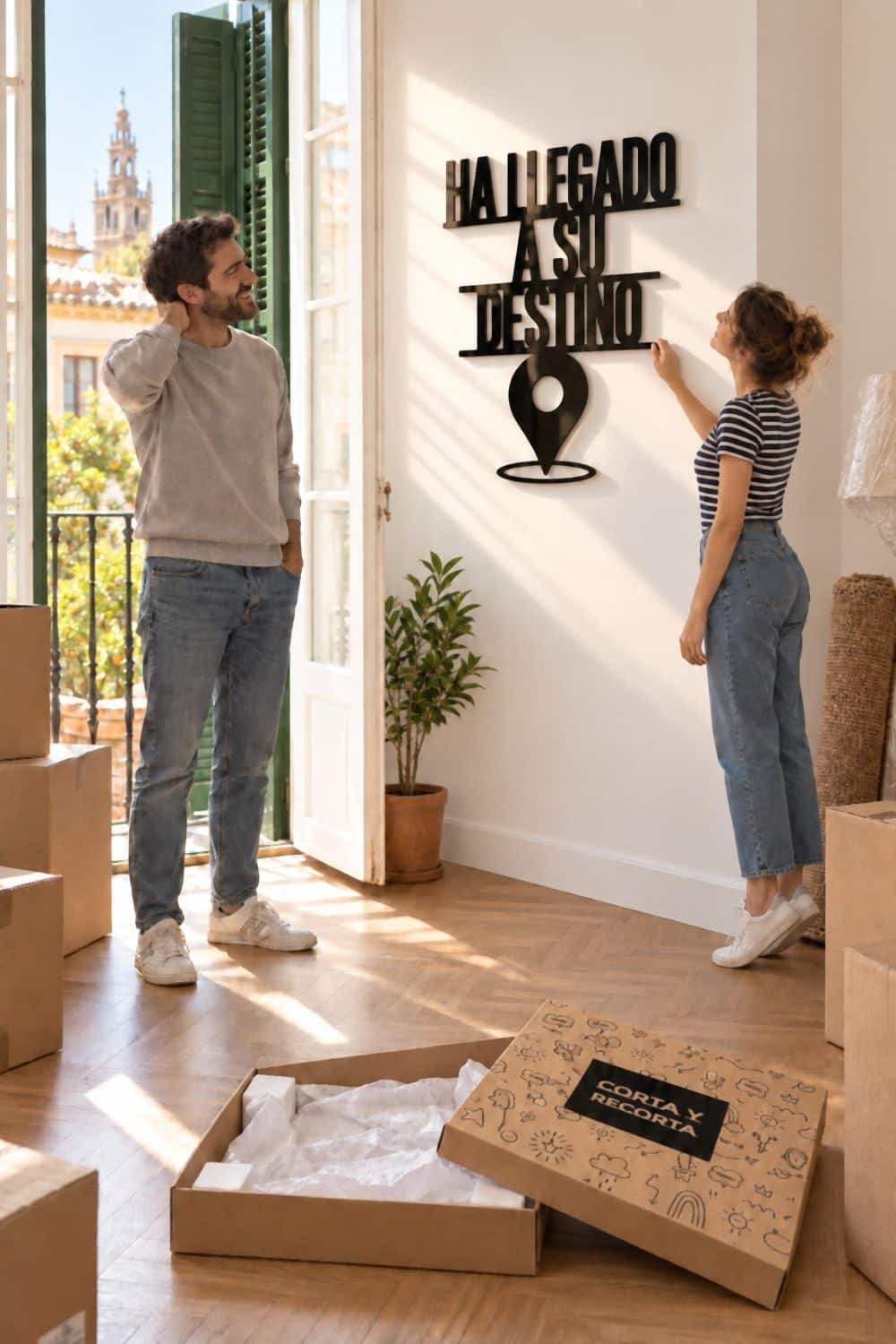 Pareja que acaba de colgar el cuadro Ha llegado a su destino en su casa nueva