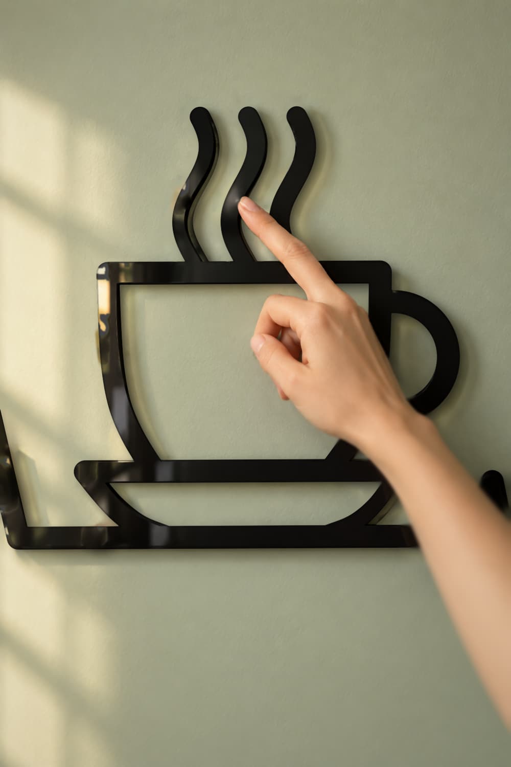 Detalle del cuadro Latidos de café: taza con vapor en aluminio negro brillante separada de la pared