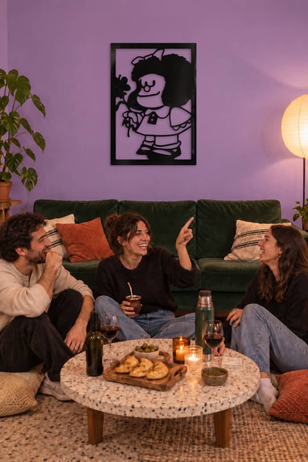 Cuadro Mafalda sobre sofá verde en salón morado, amigos con mate y empanadas