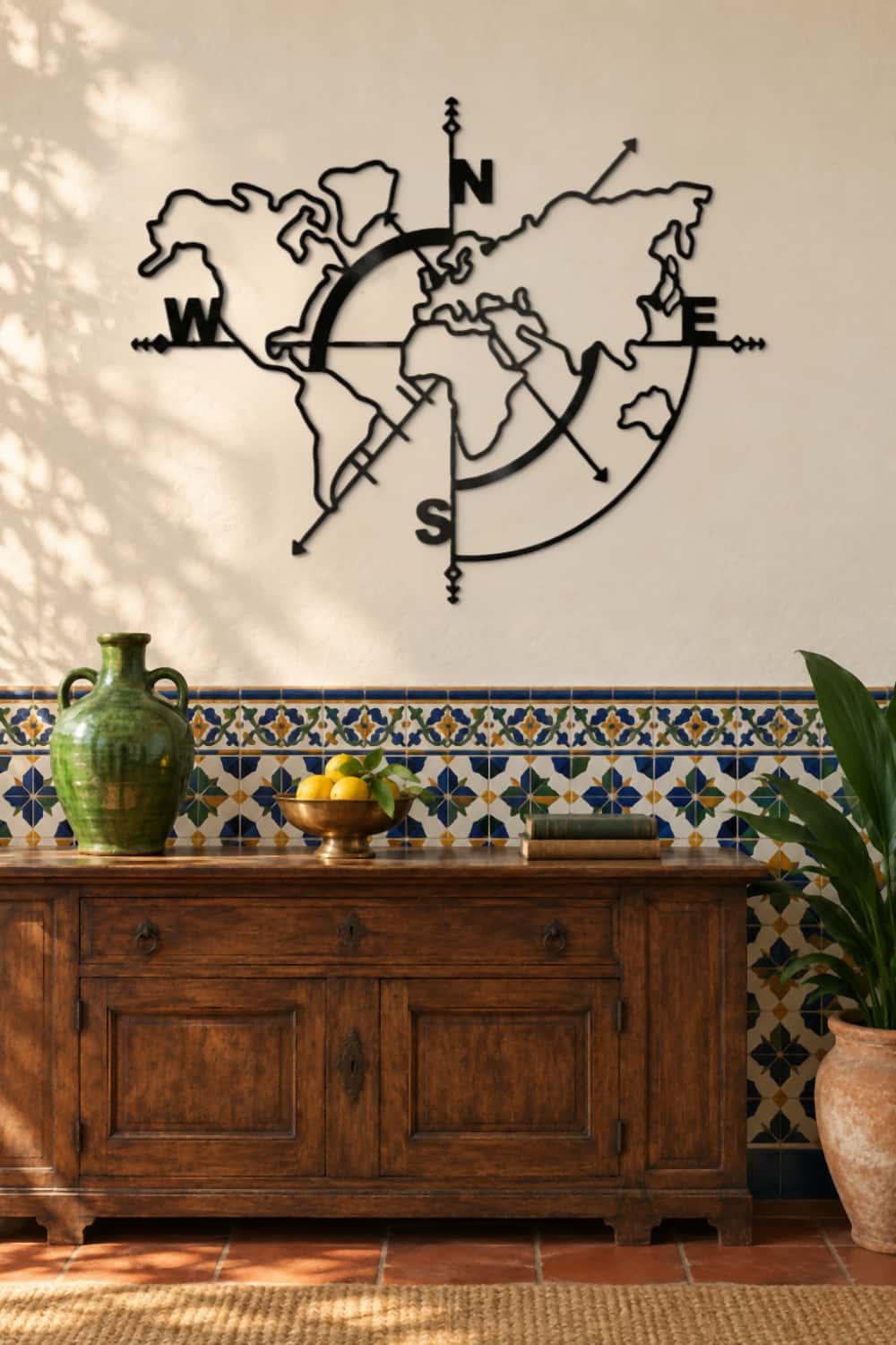 Cuadro Mapa Mundi de metal negro sobre un aparador de nogal y un zócalo de azulejos en una casa cordobesa