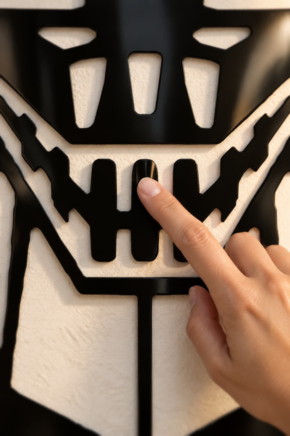 Detalle del cuadro Mazinger Z: un dedo recorre los dientes recortados en aluminio negro brillante