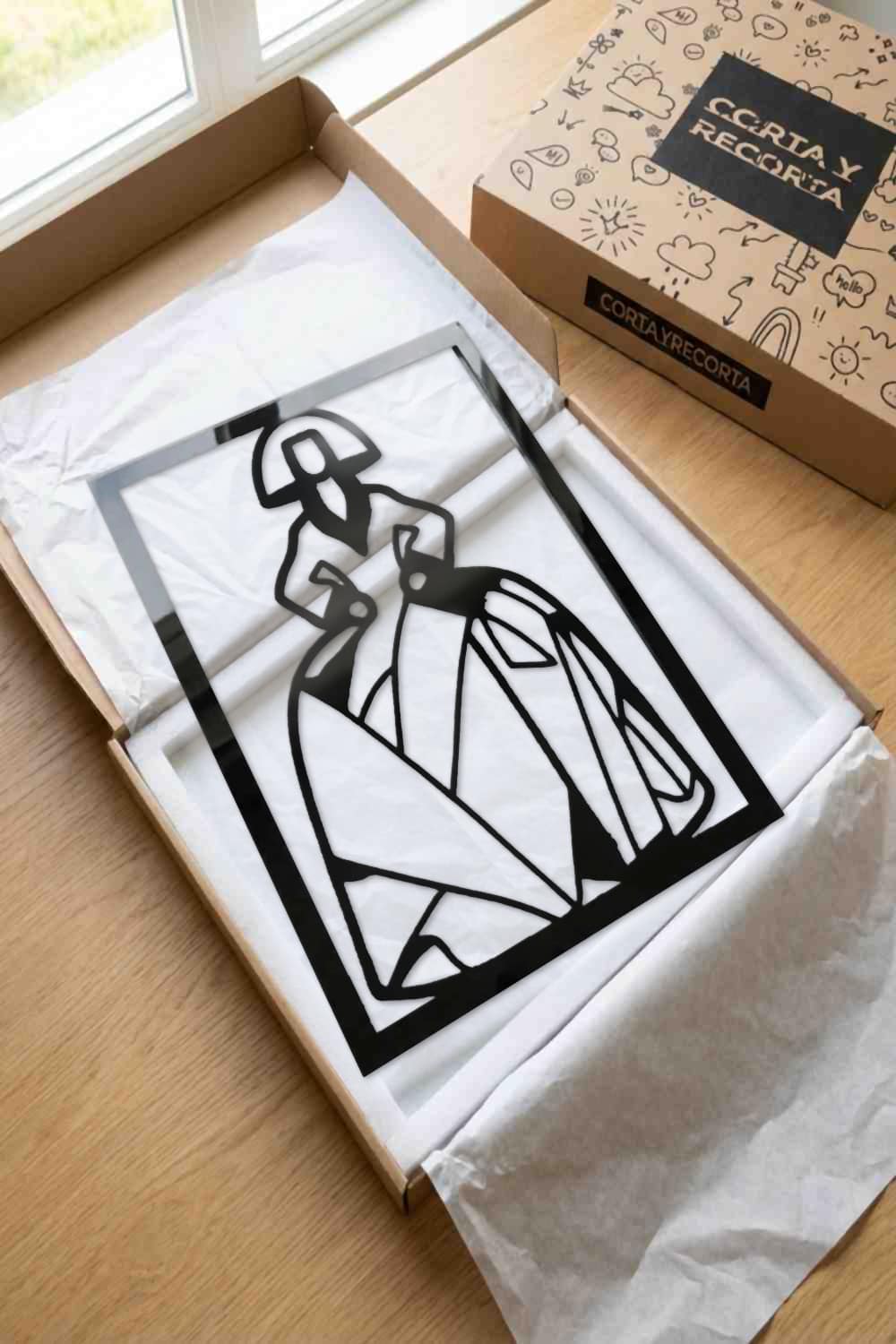 Cuadro Menina Virgina en aluminio negro dentro de su caja de Corta y Recorta, sobre papel de seda y espuma blancos