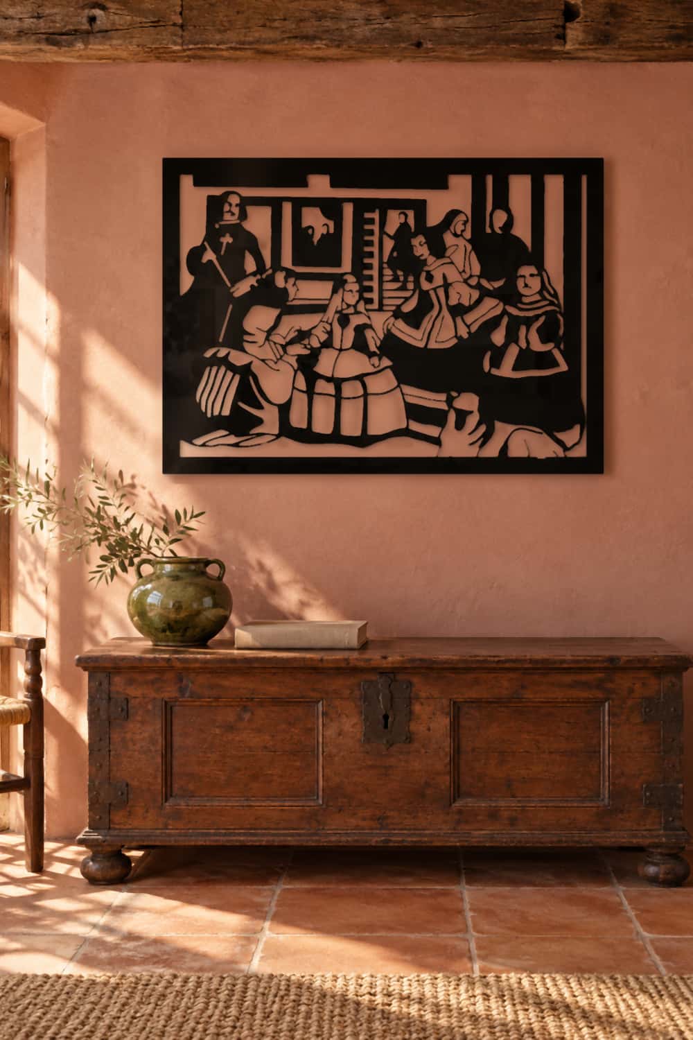 Meninas Velázquez en aluminio negro sobre arcón castellano y pared terracota.