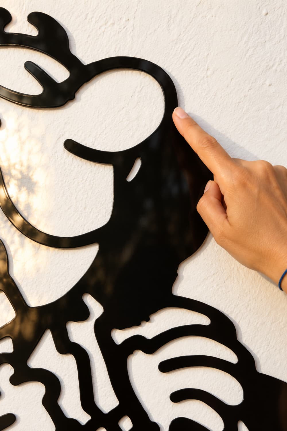 Detalle del cuadro Mortadelo y Filemón: un dedo roza la nariz de Filemón en aluminio negro brillante