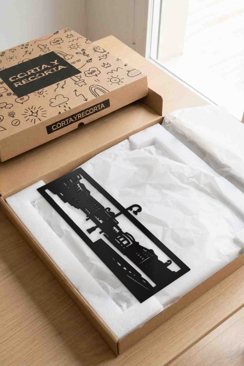 Pamplona, Plaza Del Castillo: pieza de metal en caja kraft Corta y Recorta con protección.