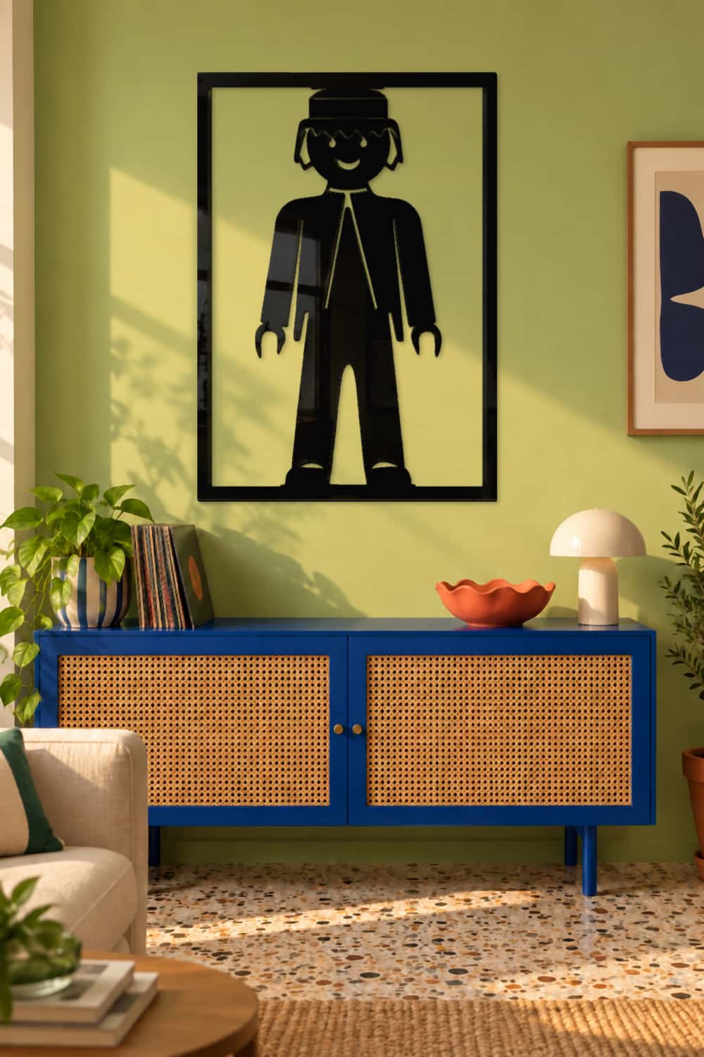 Playmobil, cuadro de aluminio negro brillante en salón urbano con ratán azul y suelo de terrazo