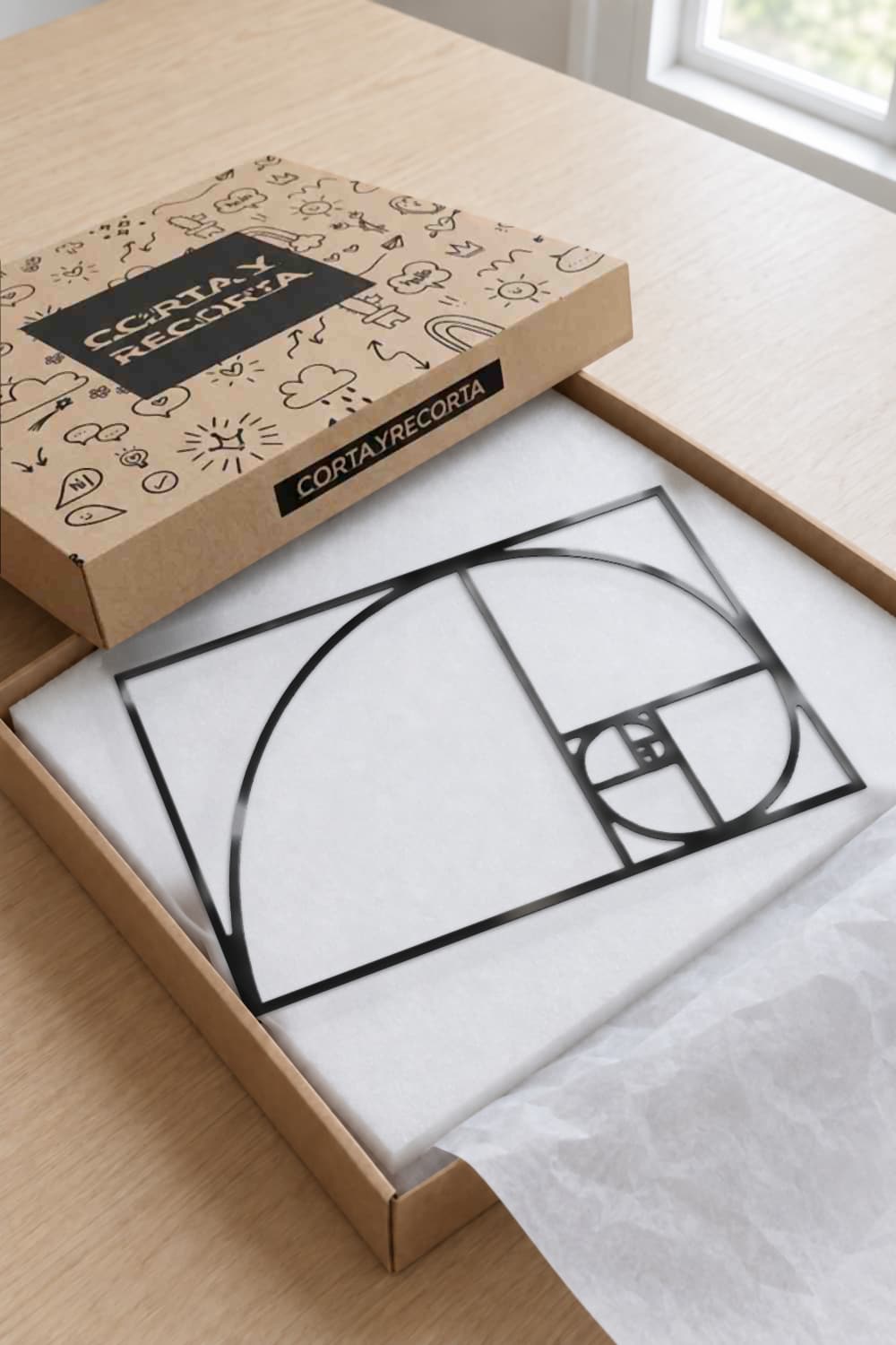 Cuadro Proporción Áurea en aluminio negro dentro de su caja de Corta y Recorta, sobre espuma blanca y papel de seda