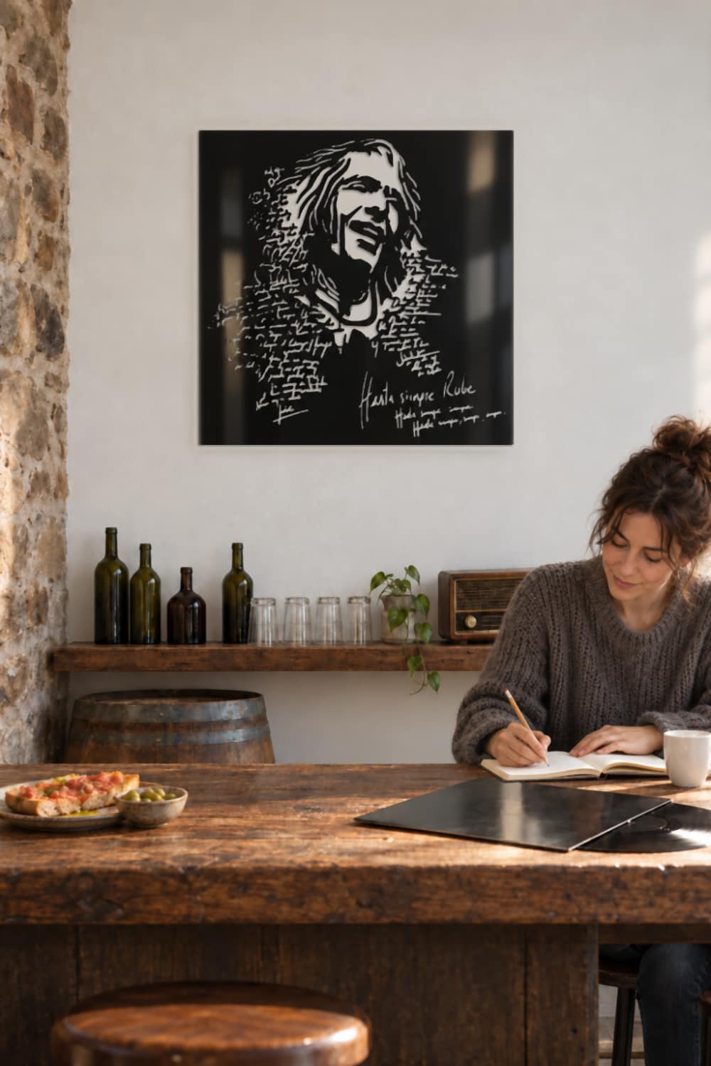 Cuadro Robe Iniesta en una cocina de pueblo, con una chica escribiendo letras de canciones