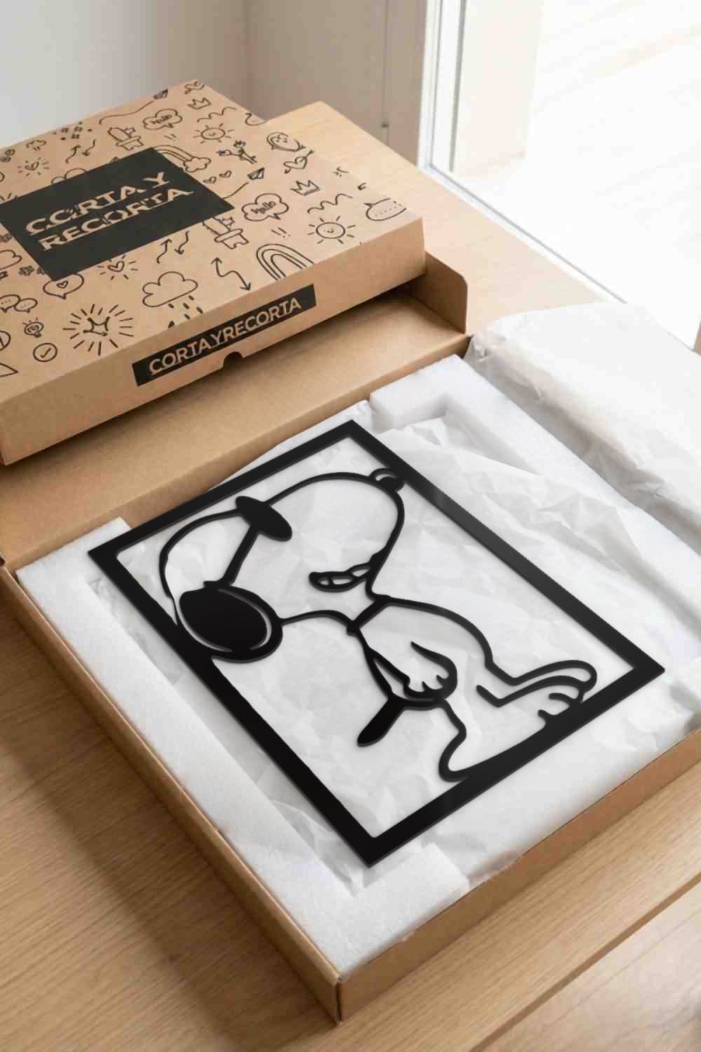 Cuadro Snoopy de aluminio negro en su caja de Corta y Recorta, protegido y listo para regalar
