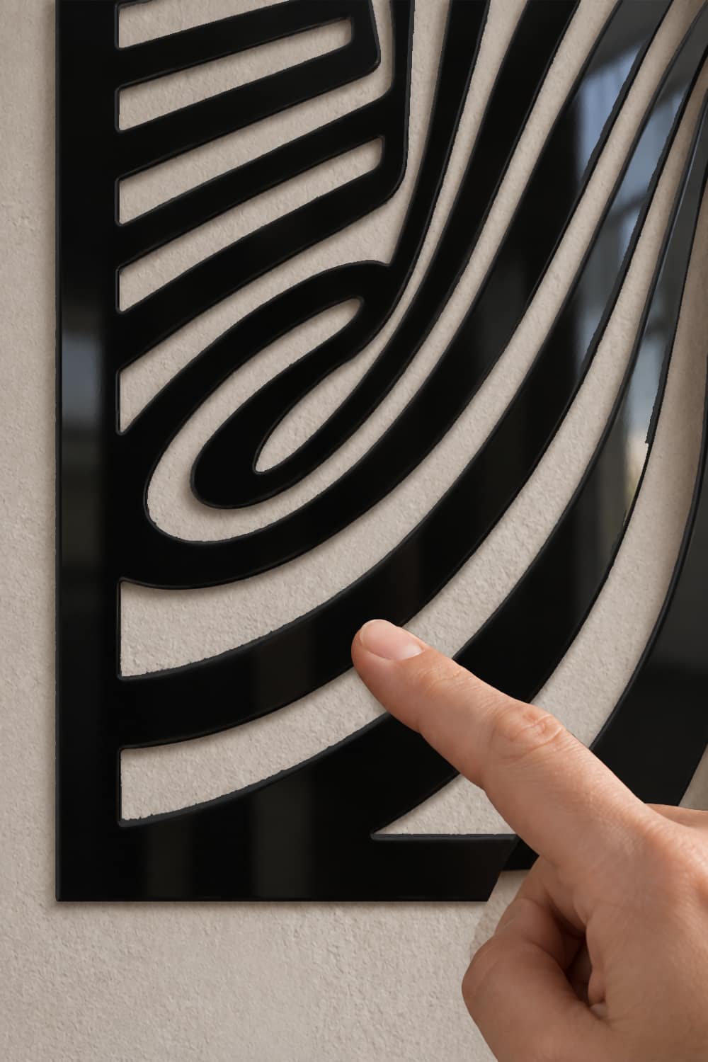 Twist, detalle del calado y la laca negra brillante con un dedo rozando una curva.