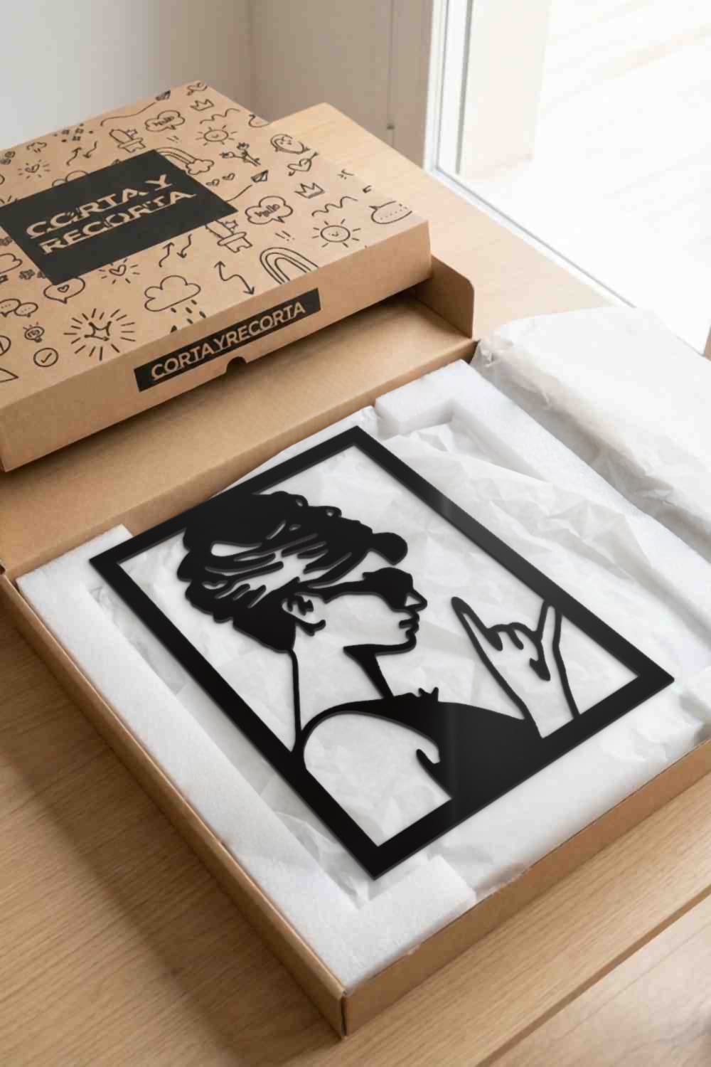 Cuadro Audrey Hepburn de aluminio negro en su caja de Corta y Recorta, listo para regalar