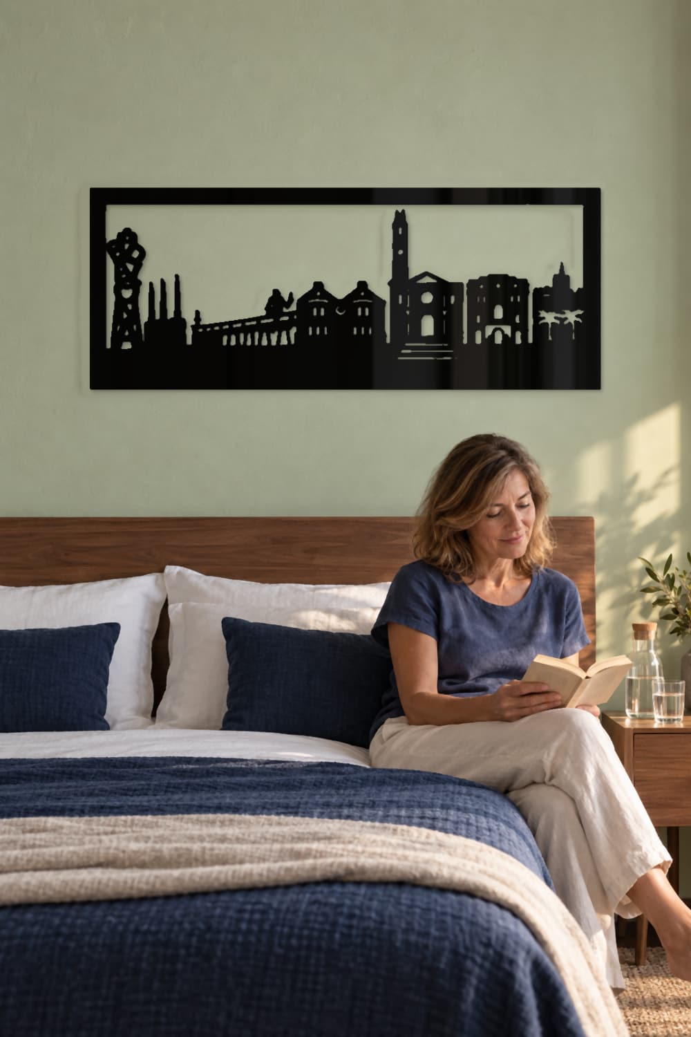 Cuadro Badalona sobre cama azul en una habitación tranquila con una lectora