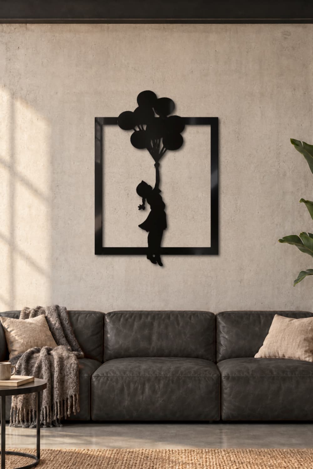 Cuadro de metal Banksy Globs, la niña de los globos, sobre un sofá de piel en un loft industrial