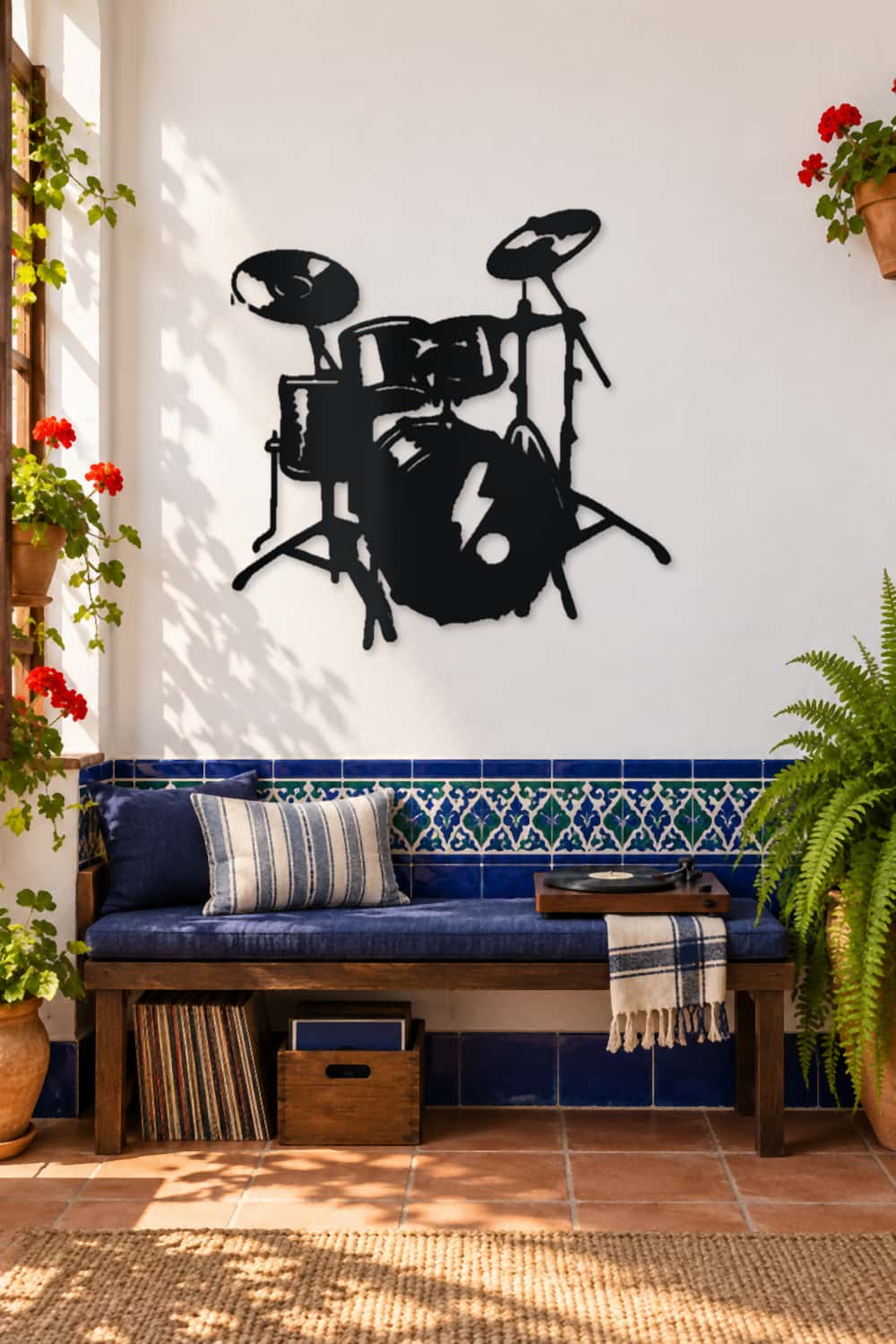 Batería de metal negro en patio andaluz con azulejos azules, plantas y tocadiscos