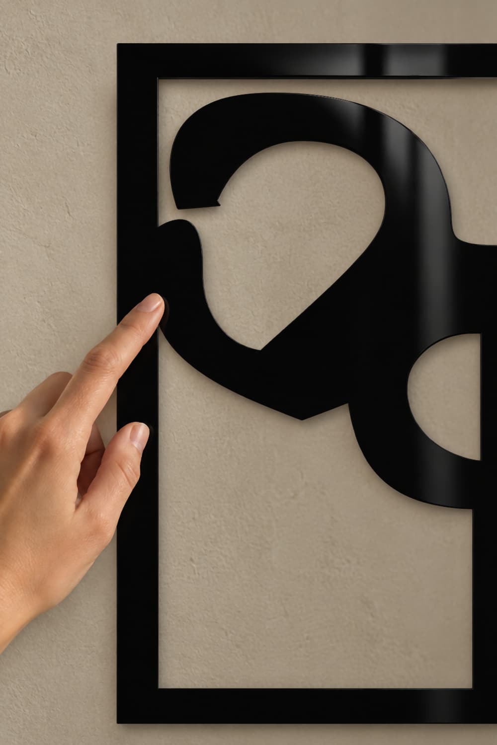 Chillida Nº01: detalle del aluminio negro brillante con un dedo tocando la curva