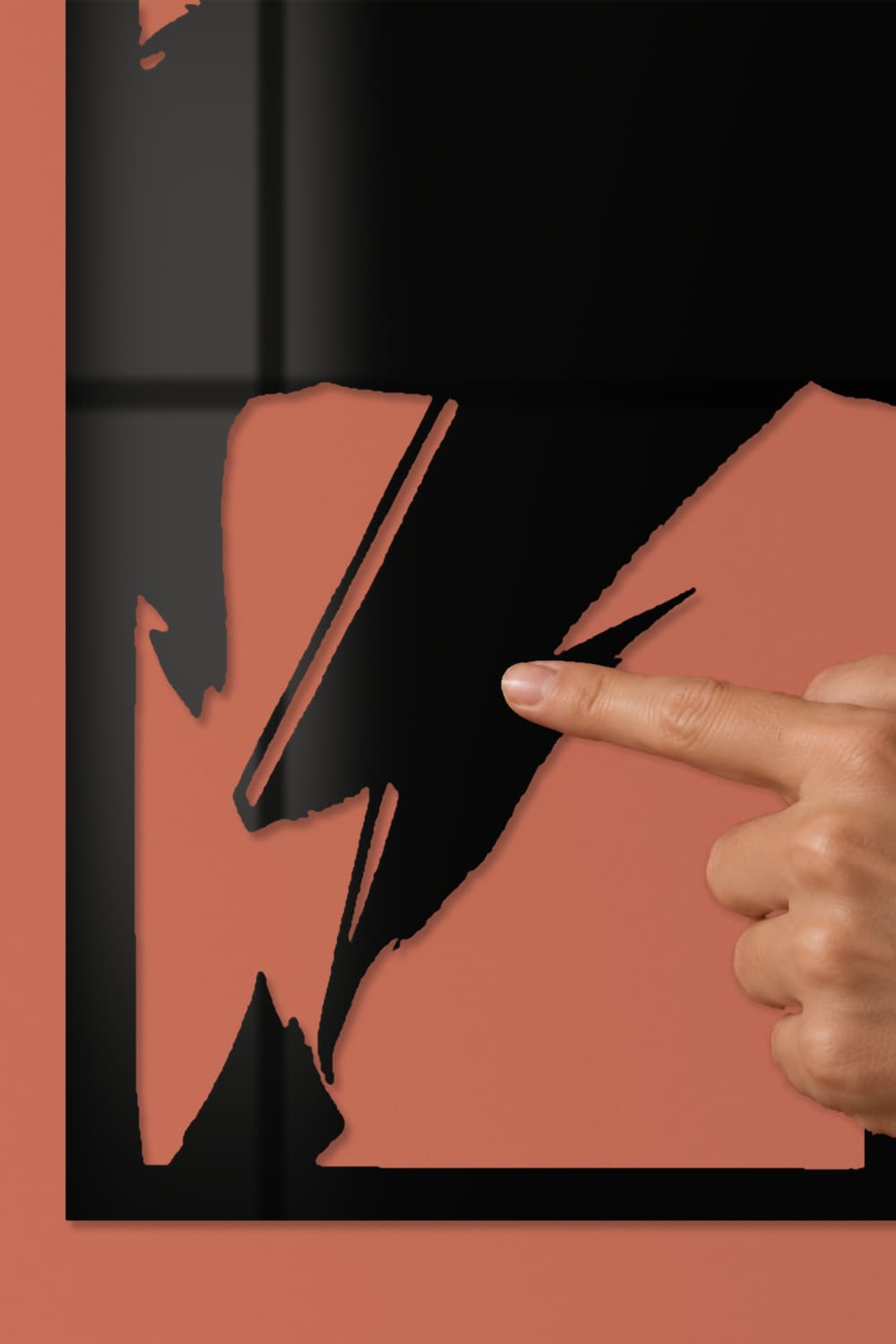 David Bowie: detalle del rayo de aluminio negro lacado con una yema de dedo sobre la pieza
