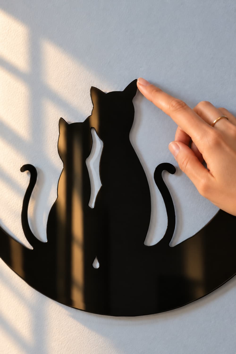 Gatos en la luna, detalle del aluminio lacado brillante y dedo sobre la oreja.