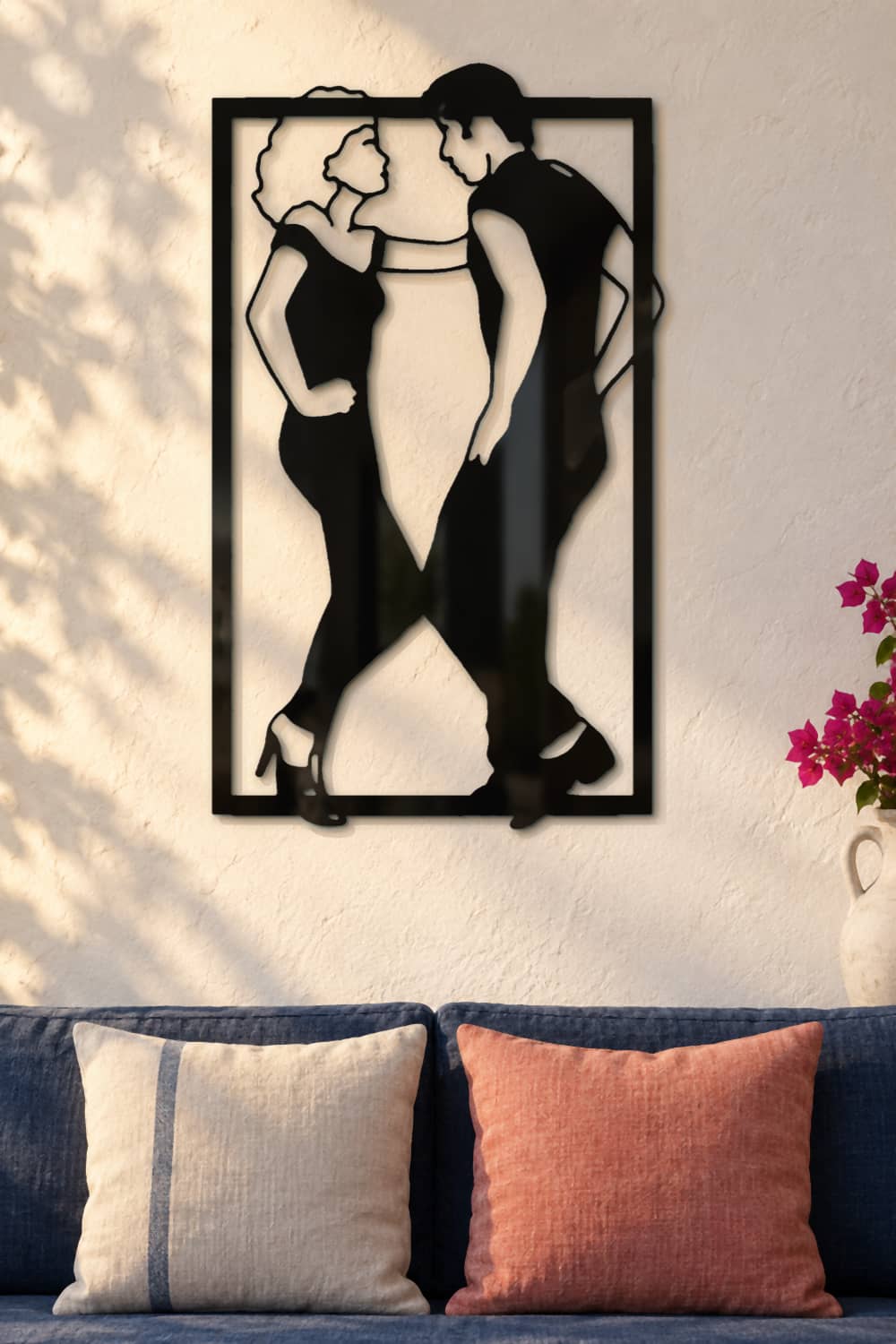 Grease, cuadro de aluminio negro sobre sofá azul en una casa mediterránea.
