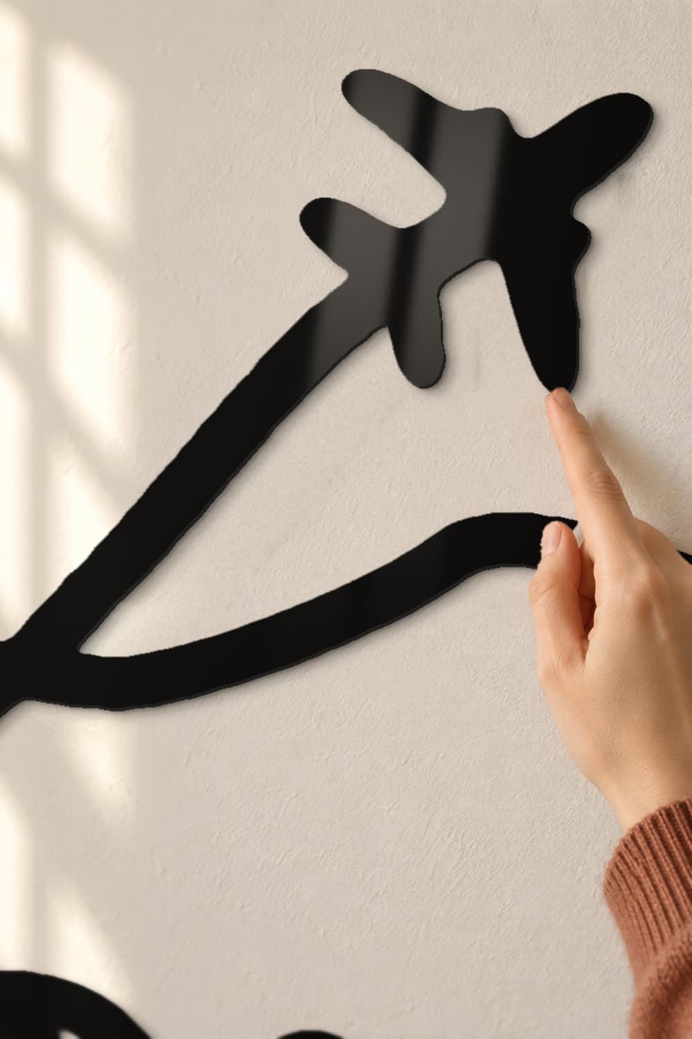 Line art mapamundi: detalle del avión de aluminio negro brillante con un dedo tocando el canto