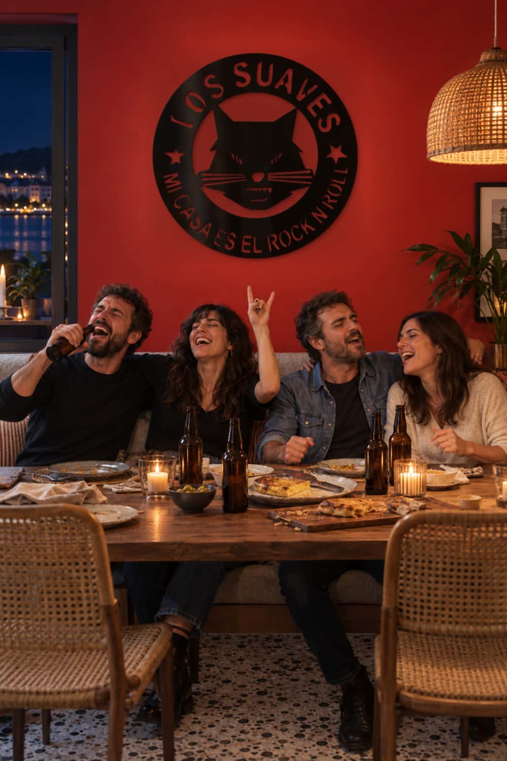 Los Suaves en un comedor rojo con amigos cantando durante una cena.