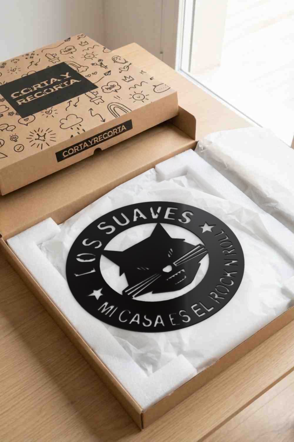 Los Suaves, cuadro de aluminio negro presentado en caja kraft Corta y Recorta.