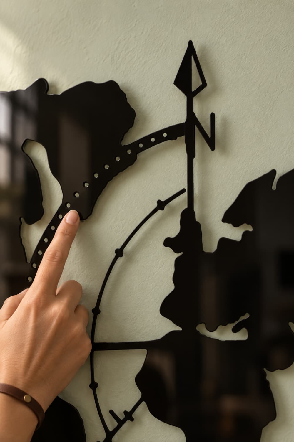 Mapa Indy: detalle de la ruta calada, laca negra brillante y un dedo sobre el metal
