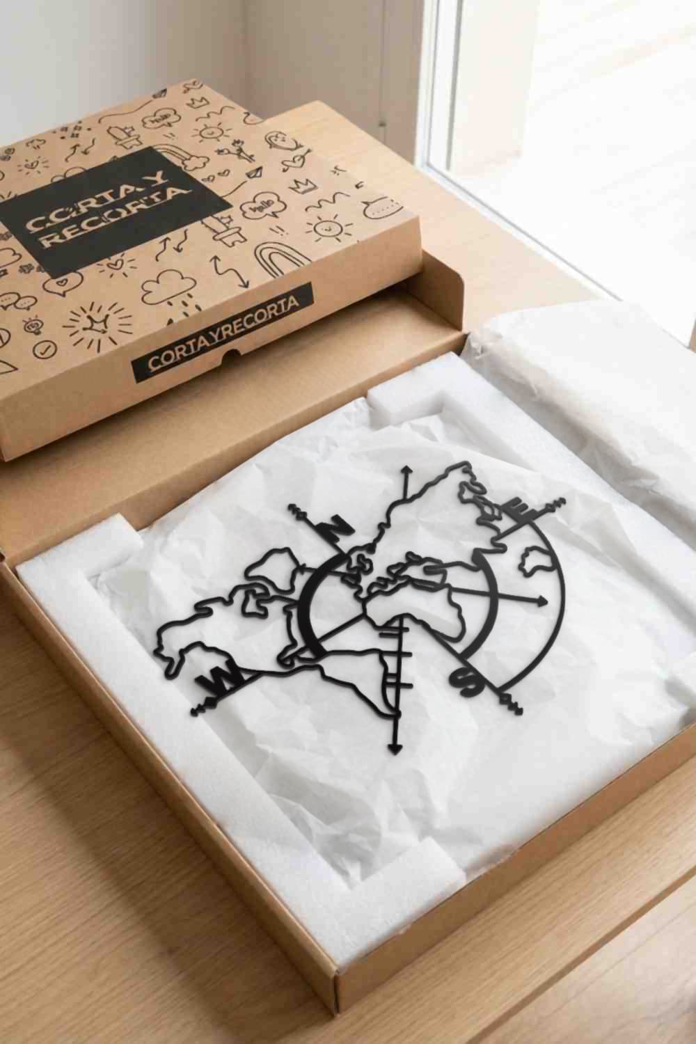 Cuadro Mapa Mundi de metal negro en su caja de Corta y Recorta, protegido con espuma y papel de seda