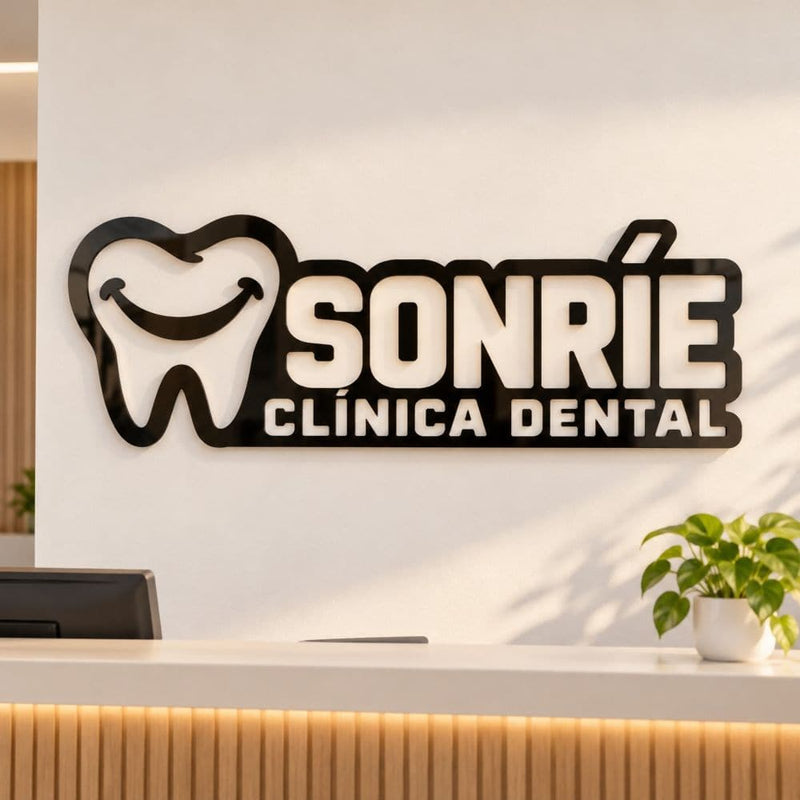 Logotipo de una clínica dental en aluminio negro, en la pared de la recepción