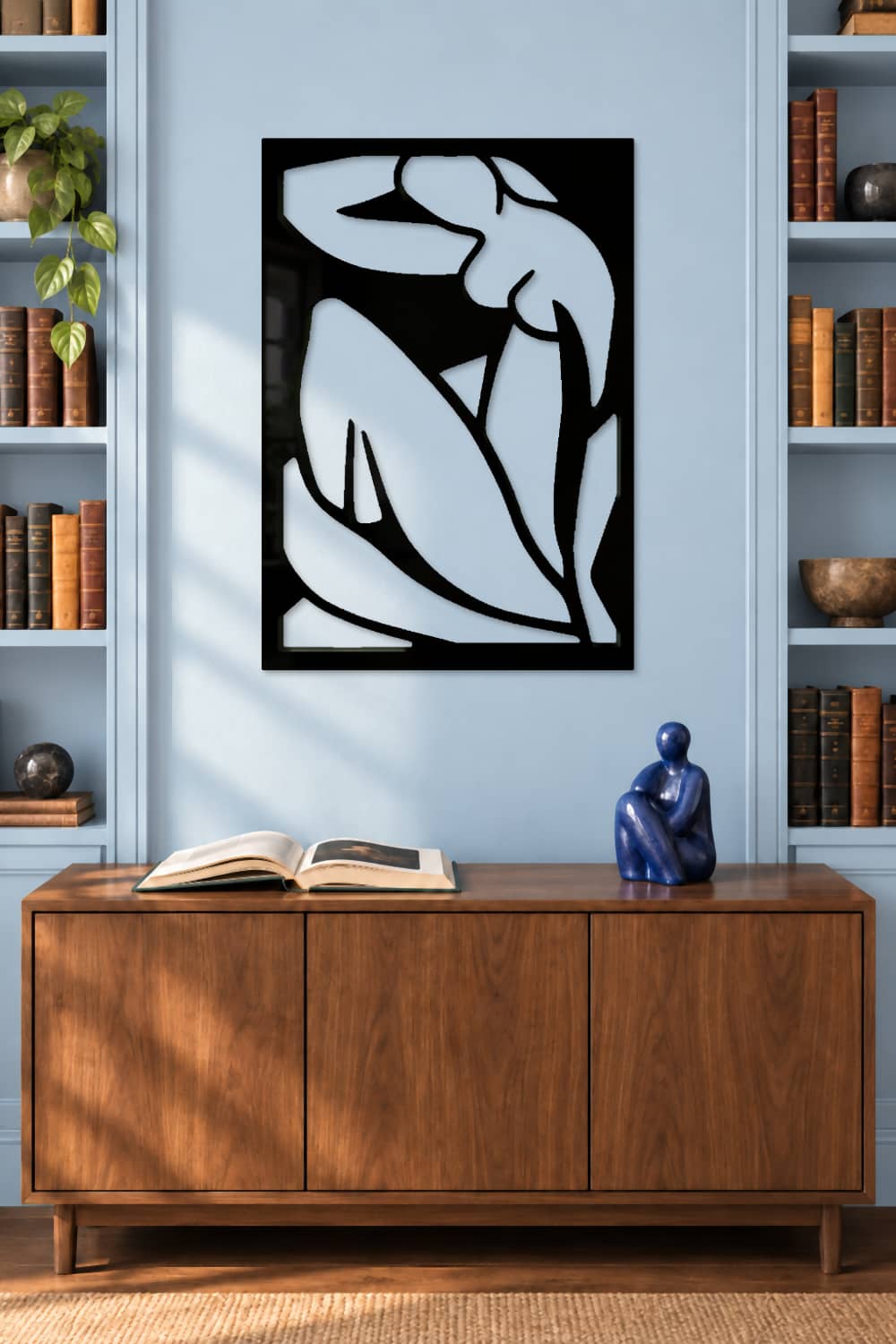 Matisse, cuadro de aluminio negro brillante sobre pared azul claro con aparador de nogal