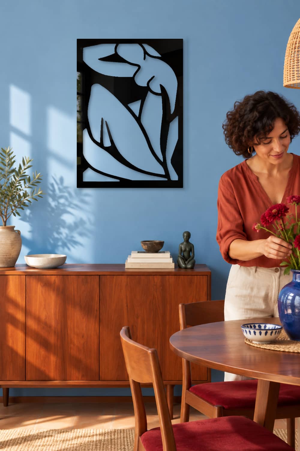 Matisse en comedor azul con una mujer preparando un jarrón de flores