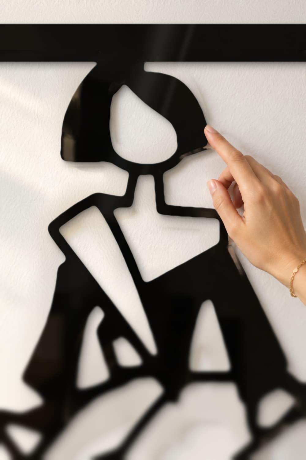 Detalle de la laca negra del cuadro Menina Quebrada: una mano roza la melena recortada en aluminio