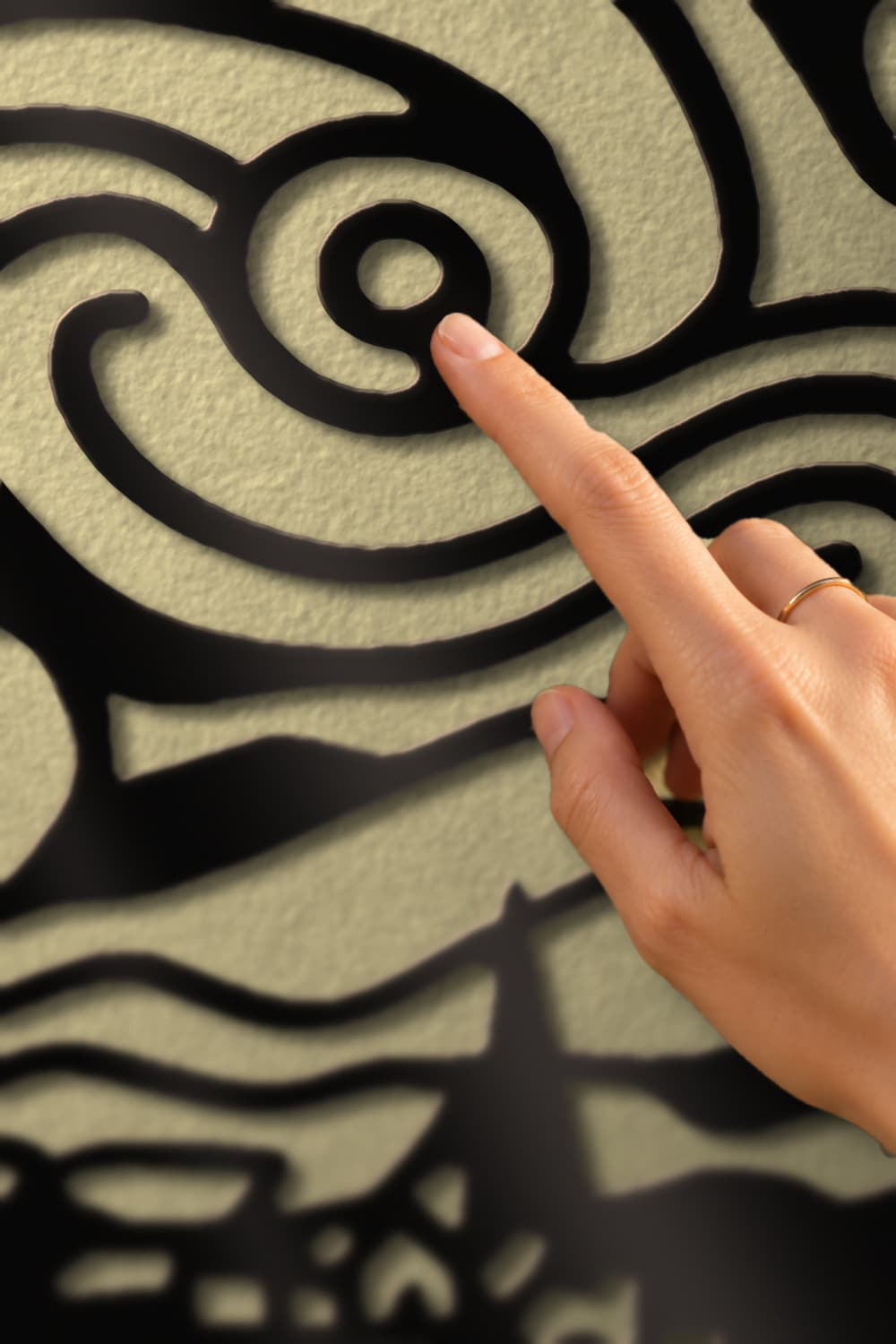Noche Estrellada: detalle de la espiral en aluminio negro con un dedo sobre el calado.