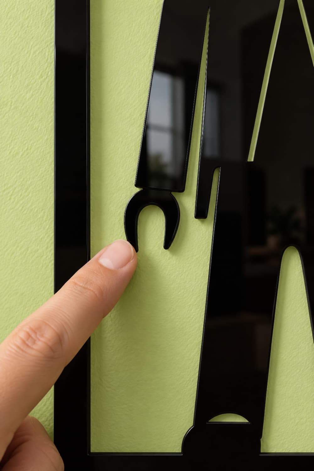 Playmobil, detalle de la mano de pinza en aluminio negro brillante con un dedo tocando el borde