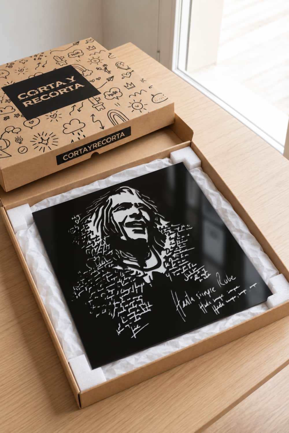 Cuadro Robe Iniesta en aluminio negro dentro de su caja de Corta y Recorta