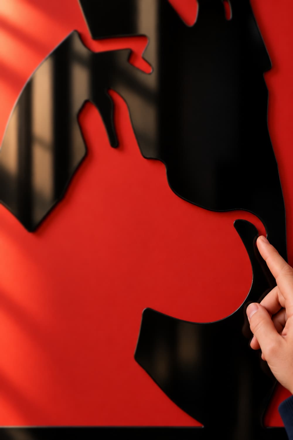Tin Tin Silueta: detalle de Milú en aluminio negro brillante con un dedo