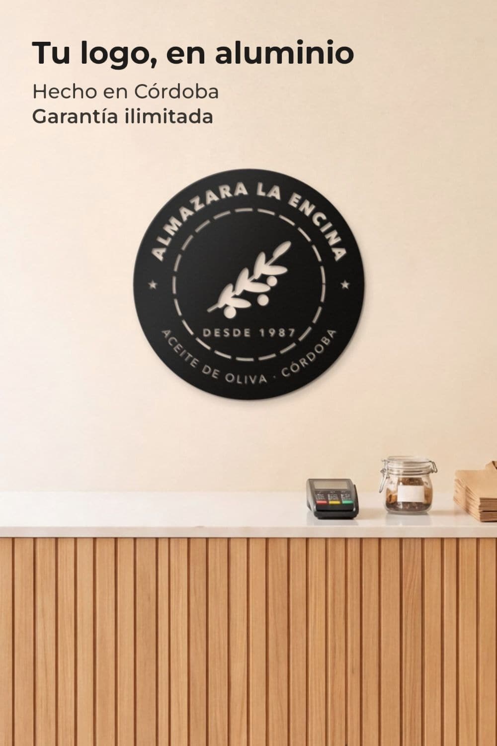 Logo de empresa en aluminio negro calado sobre un mostrador