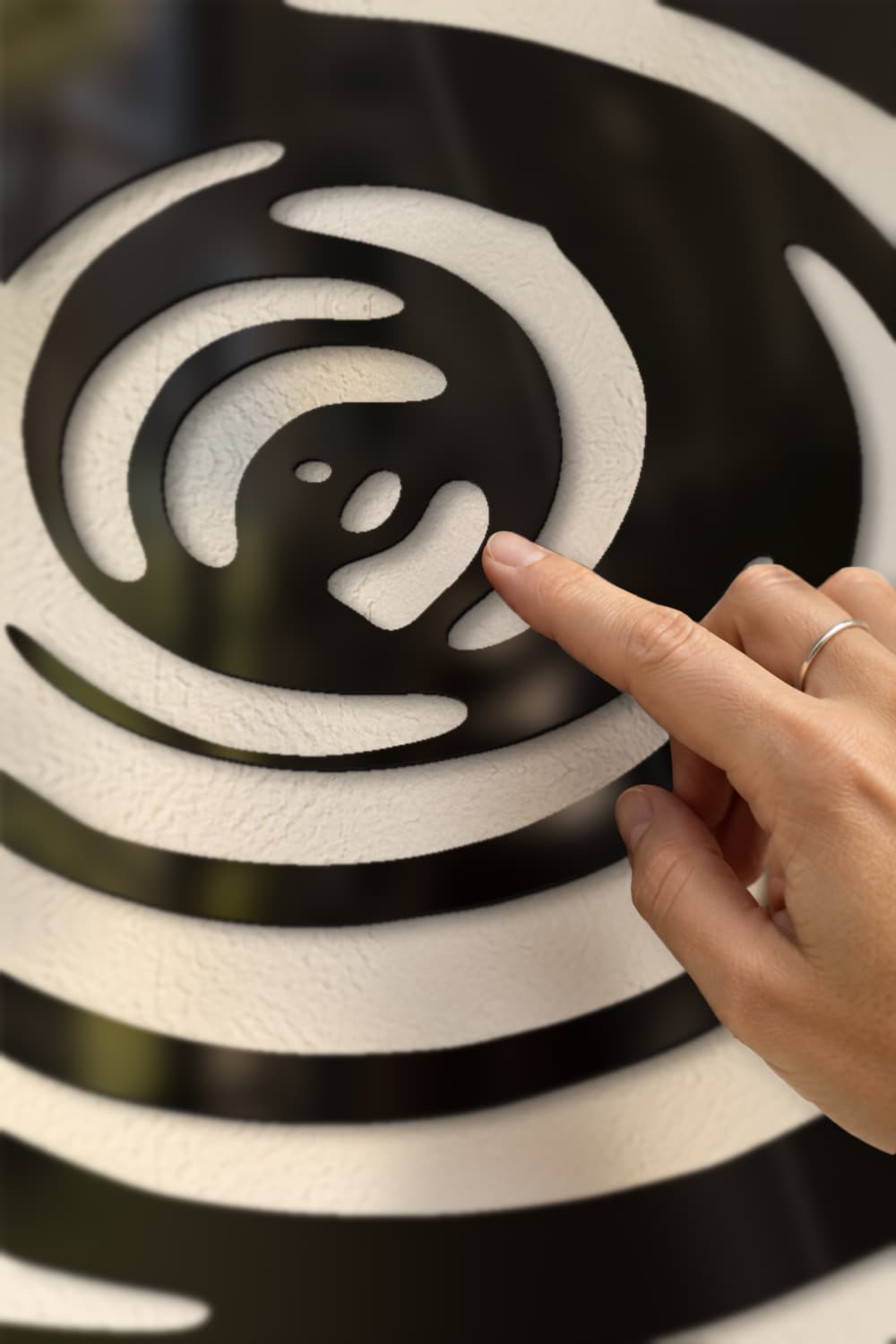 Twister Is Coming: detalle del remolino en aluminio negro brillante con una yema tocando el canto