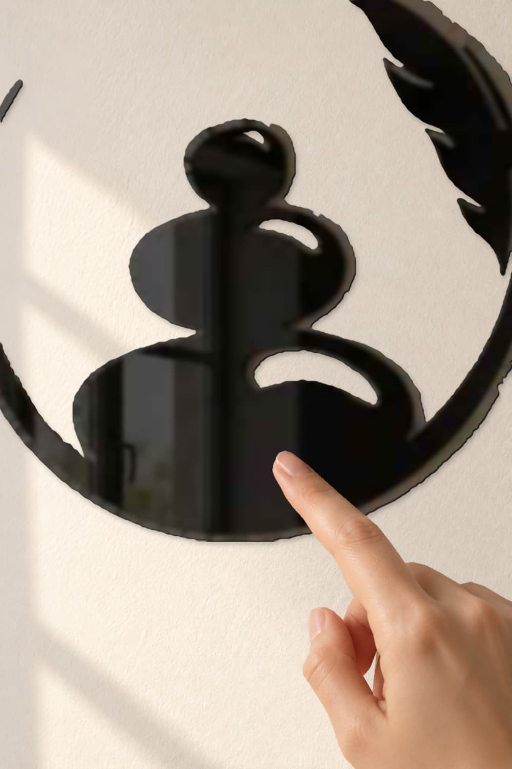 Zen Art: detalle del aluminio negro brillante con una yema tocando la piedra inferior.